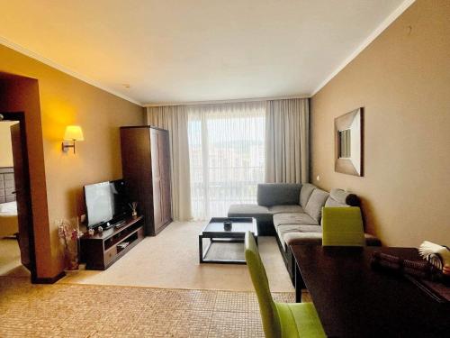 a living room with a couch and a tv at Z-apartment in 5 star hotel in Sunny Beach in Sunny Beach