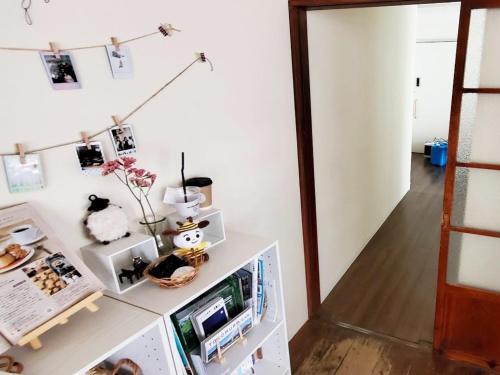 a room with white walls and a white refrigerator at ゲストハウス EZO Run Sapporo 札幌中心部でシンプルな滞在ができるホステル in Sapporo