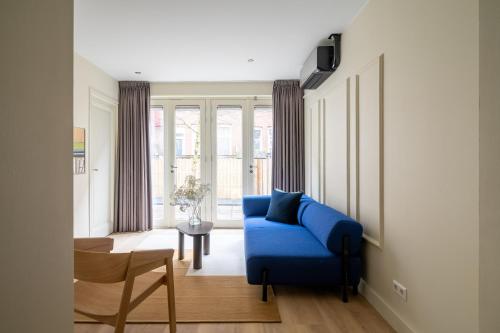 a living room with a blue couch and a table at Numa Amsterdam Oosterpark in Amsterdam