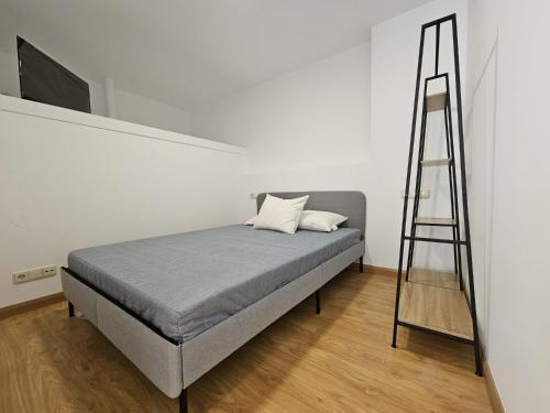 uma cama com uma escada ao lado de uma parede branca em Magnifico apartamento en Canelas em Portonovo