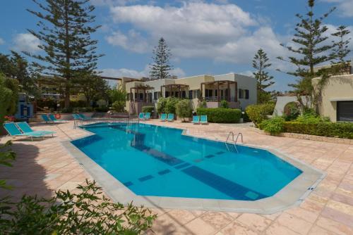 a swimming pool in a yard with a house at Your Memories Hotel in Gouves