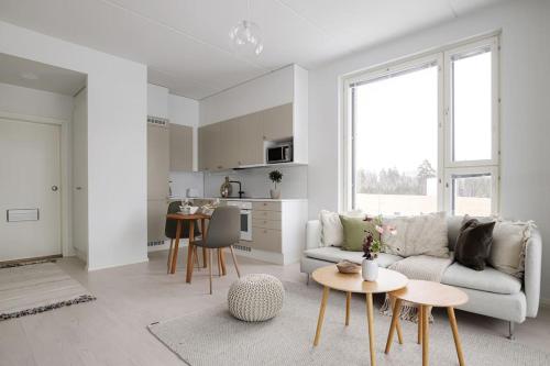 a white living room with a couch and a table at LadyCrane apartment, sauna and parking in Kirkkonummi