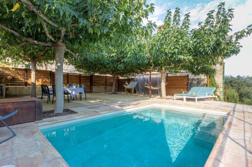- une piscine dans une cour avec une table et des chaises dans l'établissement Cal Sabater, à Las Escaulas