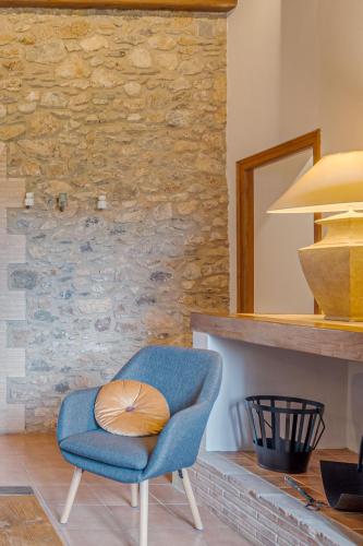 a blue chair sitting in front of a fireplace at Majordoms - Cal Sabater in Las Escaulas