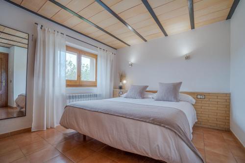 - une chambre avec un grand lit et une fenêtre dans l'établissement Cal Sabater, à Las Escaulas