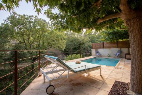 a patio with a pool and a chair next to a tree at Majordoms - Cal Sabater in Las Escaulas