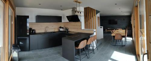 a kitchen with a counter and a table with chairs at Chalet La Gave/La Meije in La Grave
