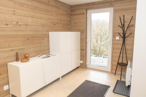 Cette chambre comprend une armoire blanche et une fenêtre. dans l'établissement Le refuge des Gouttridos, imprenable vue lac 4-5p, à Gérardmer