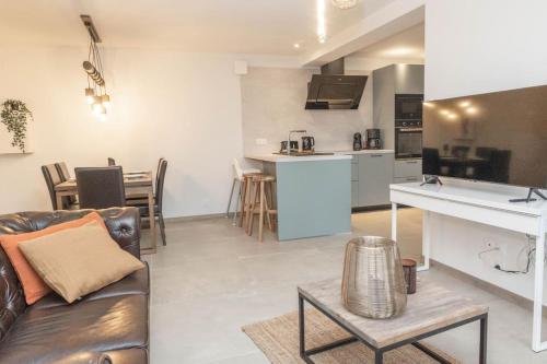 un salon avec un canapé et une cuisine dans l'établissement Le refuge des Gouttridos, imprenable vue lac 4-5p, à Gérardmer