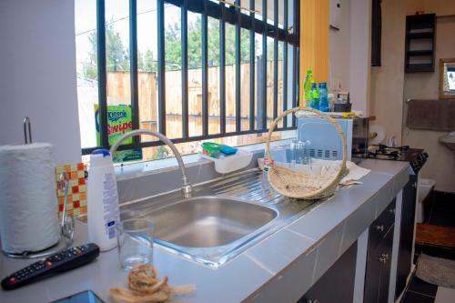 a kitchen counter with a sink and a window at Superb High spec Studios . Kabete. 15 Mins from Westlands in Nairobi