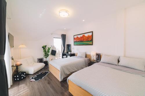 a hotel room with two beds and a couch at Darest's Home in Da Lat