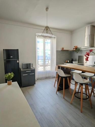 een keuken met een tafel en stoelen in een kamer bij 11 Trachel - Charmant T2 spacieux à proximité de gare Thiers in Nice