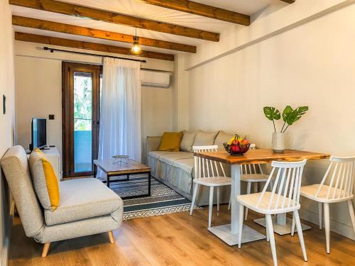 a living room with a couch and a table and chairs at Apellou Apartments in Vathý