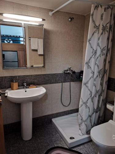 a bathroom with a sink and a shower curtain at Floras House in Karistos