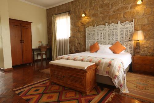 a bedroom with a bed and a stone wall at Zereniti House in Muyaka