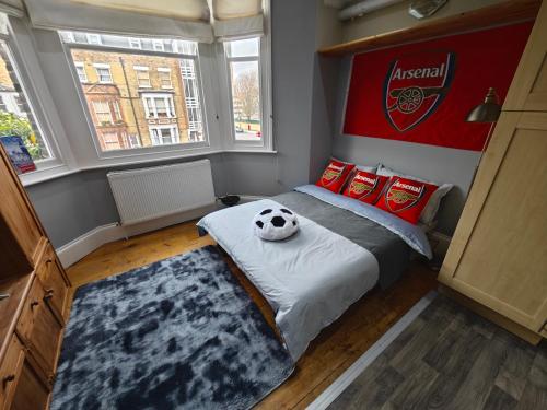 a bedroom with a bed with a soccer ball on it at LOVELY 1 BEDROOM FLAT IN FINSBURY PARK/EMIRATES STADIUM in London