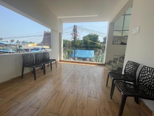 an empty room with three chairs and a large window at MKS Homes in Tirukkadaiyūr