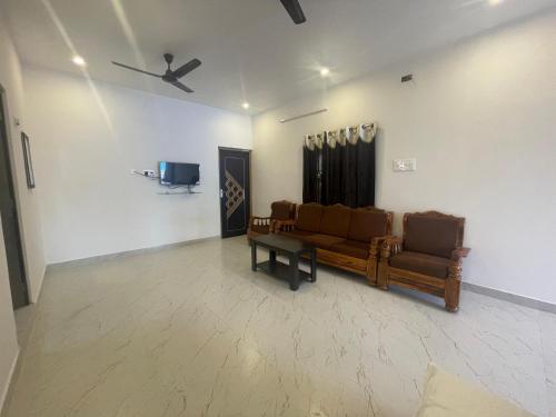 a living room with a couch and a tv at MKS Homes in Tirukkadaiyūr