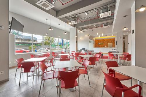 a dining room with tables and red chairs at City Express Junior by Marriott San Luis Potosi Zona Industrial in San Luis Potosí