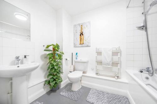 a white bathroom with a toilet and a sink at Impressive Central London Balcony Apartment in London