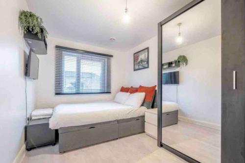 a bedroom with a large bed and a mirror at Impressive Central London Balcony Apartment in London