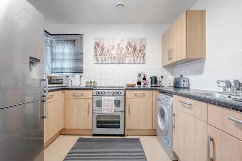 a kitchen with a stove and a dishwasher at Impressive Central London Balcony Apartment in London