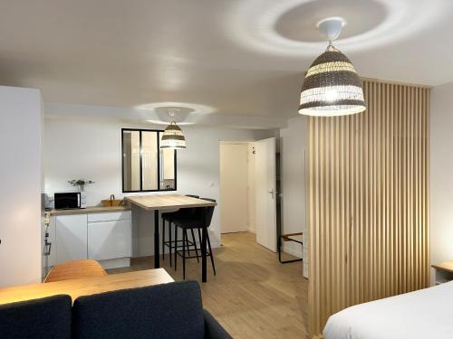 une chambre avec un lit et une cuisine avec une table dans l'établissement Appartement place de la république - Lille, à Lille