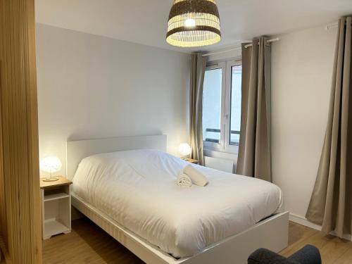 um quarto com uma cama branca e uma janela em Appartement place de la république - Lille em Lille