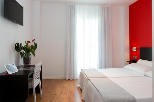 a bedroom with a bed and a desk with a laptop at NRuta Ponferrada in Bembibre