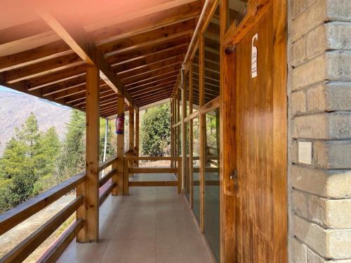 ein Holzhaus mit einem Balkon mit Aussicht in der Unterkunft Whispering Woods Resort in Thimphu