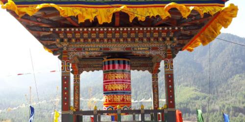 a colorful structure with a mountain in the background at Whispering Woods Resort in Thimphu