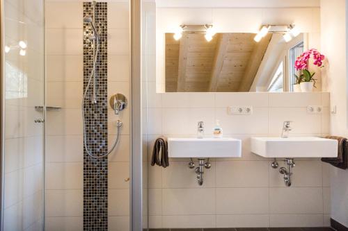 a bathroom with two sinks and a shower at Haus Alpgaustraße - Ferienhäuser Alpenglück in Oberstdorf