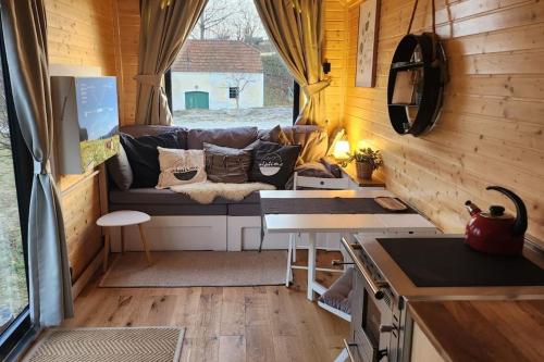 a living room with a couch in a tiny house at Behagliches OFFGRID Tiny House - Escape to Nature in Sankt Pölten