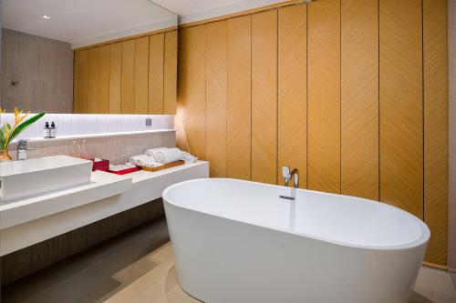 a bathroom with a white tub and a sink at Ramada Resort by Wyndham Khao Lak in Khao Lak