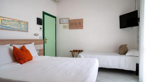 two beds in a room with a green door at Mare Home Brunch&Beauty - Adults Only in Cesenatico
