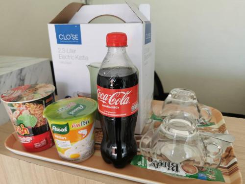 eine Flasche Kokain und andere Lebensmittel auf einem Tablett in der Unterkunft NST Boutique เอ็นเอสทีบูทีค in Ban Pak Phun