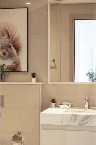 a bathroom with a sink and a picture of a squirrel at SmartStay at Burj Royale - Full Burj Khalifa View - Brand New Luxury Apartments in Dubai