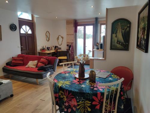 Maison de village au calme axe Annecy - Genève في فييِ لو بولو: غرفة معيشة مع طاولة وأريكة