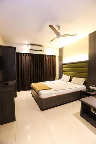 1 dormitorio con 1 cama y ventilador de techo en SAHARA LODGING & BOARDING en Mire