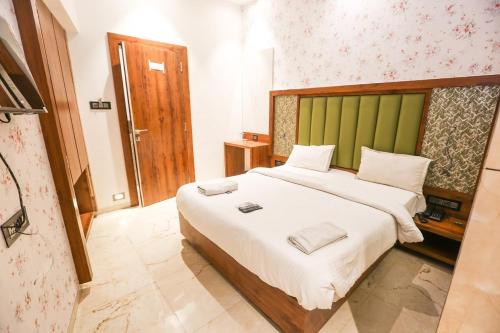 a bedroom with a large bed with a green headboard at SAHARA LODGING & BOARDING in Mire