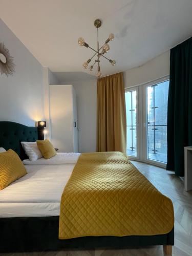 ワルシャワにあるWarsaw Concierge Towerのベッドルーム1室(大型ベッド1台、黄色い毛布付)
