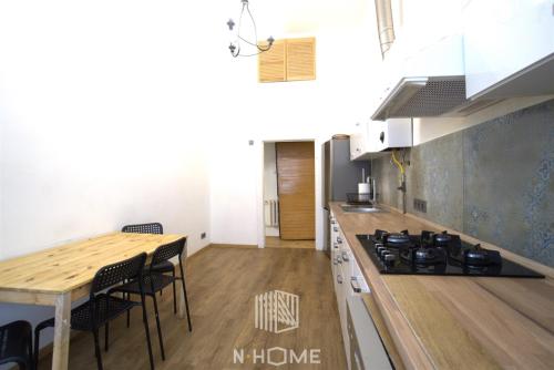 a kitchen with a stove and a table with chairs at Apartament z kominkiem in Łódź