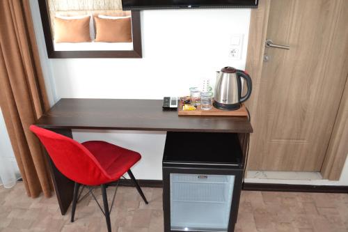 a room with a desk with a red chair and a microwave at HOTEL GLOBAL 2022 in Istanbul