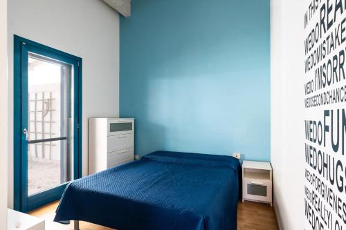 una camera blu con un letto e una finestra di Casa Ulivi al mare by Wonderful Italy a Bisceglie