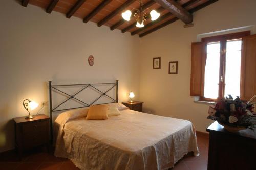 een slaapkamer met een bed en twee lampen op tafels bij Comiti Farmhouse Apt Venere in Montaione