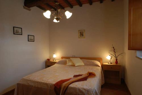a bedroom with a bed with two lights on the wall at Comiti Farmhouse Apt Bondone in Montaione