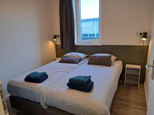 een slaapkamer met een bed met twee handdoeken erop bij 107,5 Nieuw appartement met sauna in Westkapelle