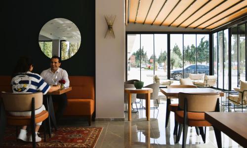a man and a woman sitting at a table in a restaurant at Pamukkale Kaya Termal Otel in Pamukkale