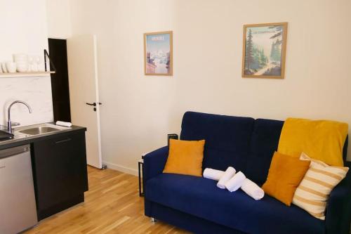 un canapé bleu avec des coussins jaunes dans un salon dans l'établissement Le Petit Paradis Grenoblois, à Grenoble