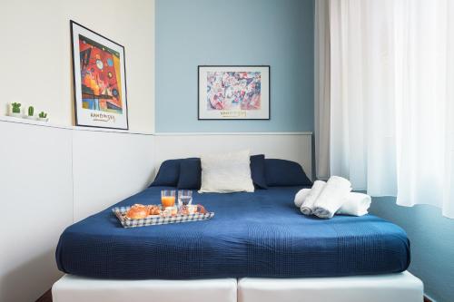 a blue bed with a tray of fruit on it at Orizzonte Apartment Amazing Sea View in Pozzallo
